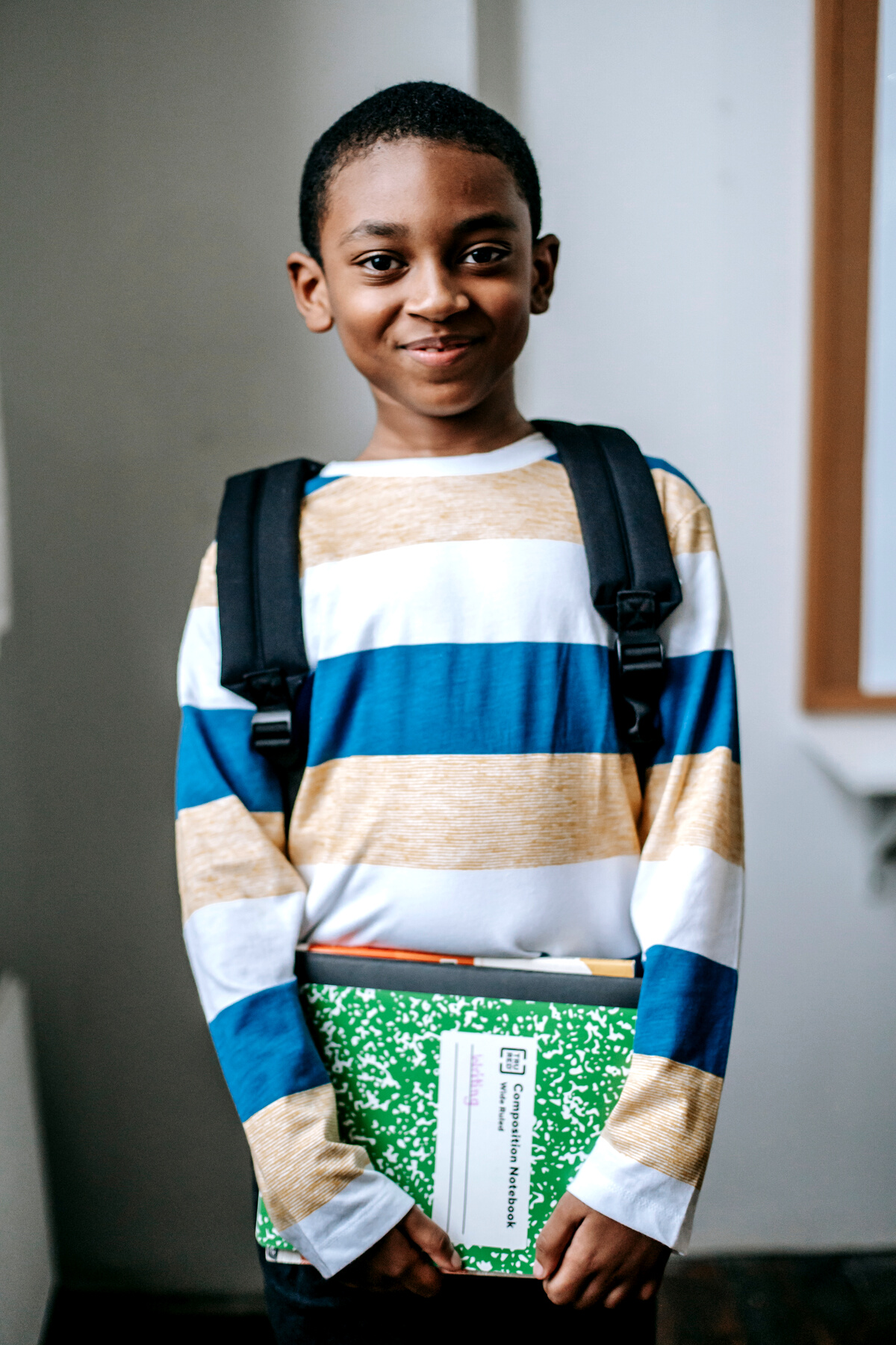 Smiling black child standing in classroom and looking at camera
